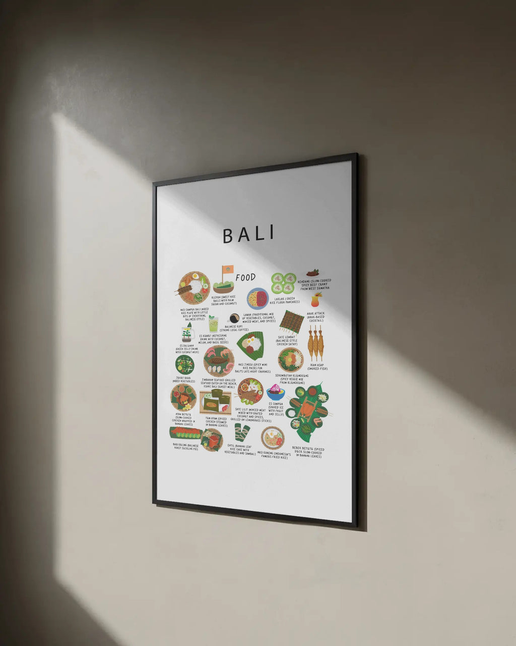 Angled view of an illustrated Bali food poster in a slim black frame, hanging on a beige wall bathed in diagonal sunlight and shadows.
