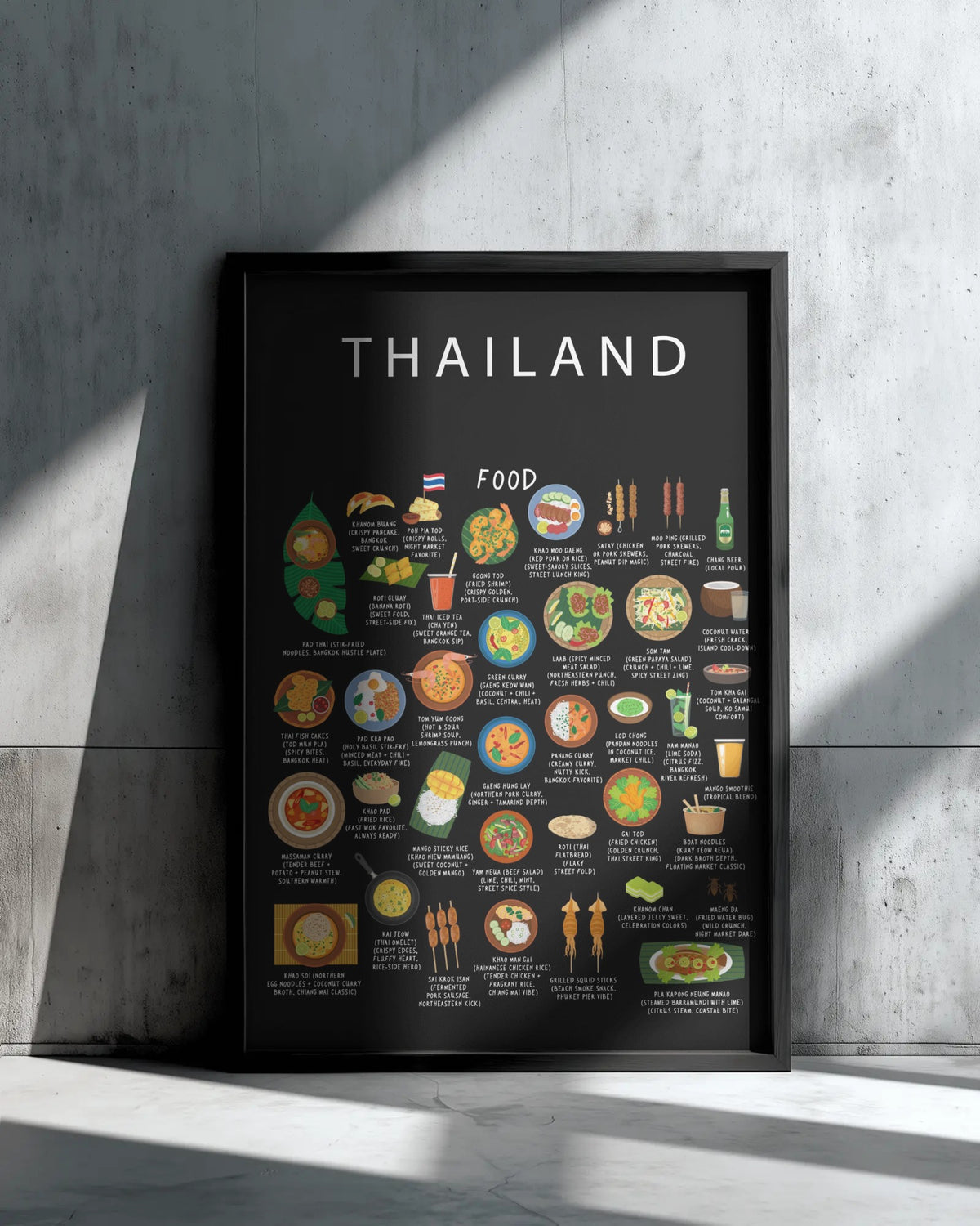 A black Thailand food poster in a sleek black frame rests against a textured concrete wall with angled sunlight casting shadows.
