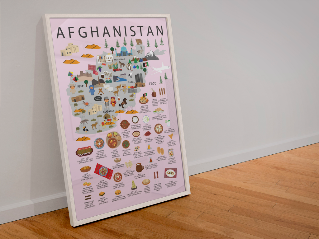 A framed travel poster of Afghanistan leaning against a white wall on a light wood floor. The poster features a light pink background with detailed, colorful cartoon illustrations of the country's landmarks, food, and culture, and is enclosed in a white frame.